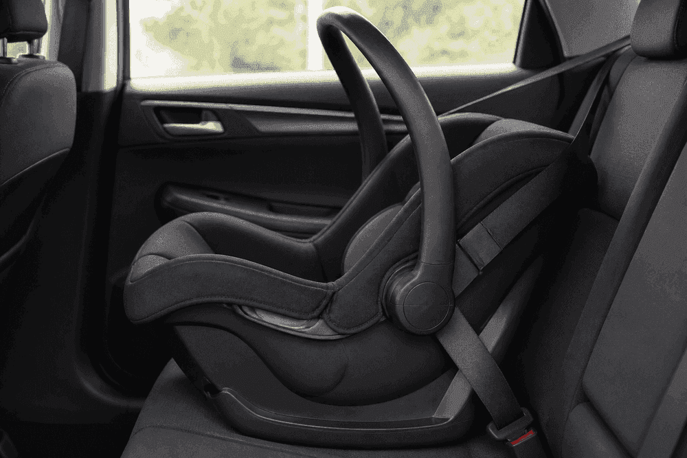 Empty rear-facing infant car seat installed in a vehicle back seat.