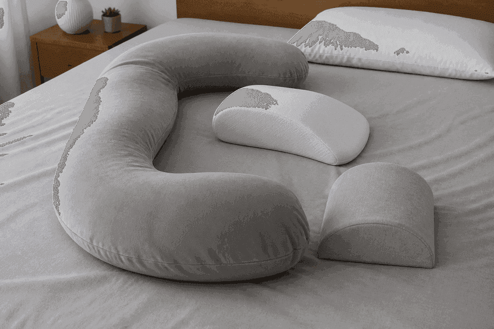 Pillows arranged to support left-lateral positioning on a bed.